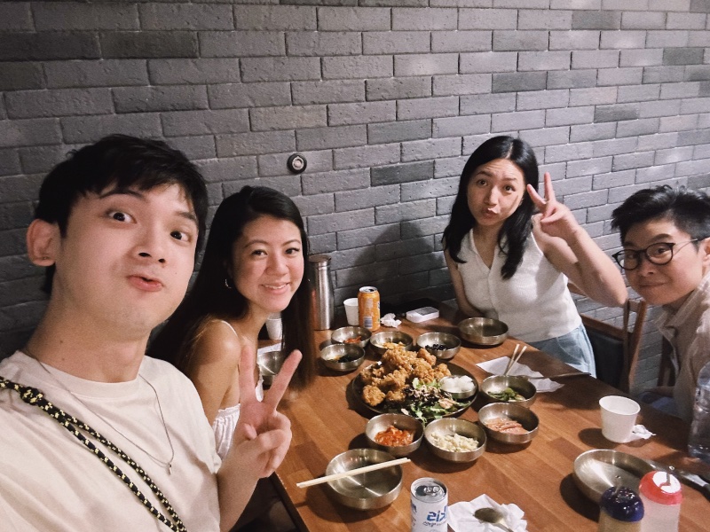 Izac and his Melbourne friends sharing a meal around a restaurant table.